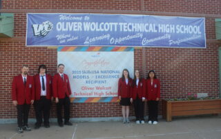 Staff and students stand in front of SkillsUSA banner outside of Wolcott Tech school building